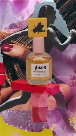 Gisou honey-infused hair perfume bottle with a pink cap and a yellow label, displayed on stacked pink and red blocks in a collage.