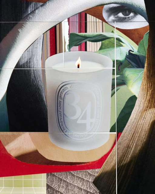 Frosted candle on a surface with books and a drawing of an eye in the background, creating a still life product shot.