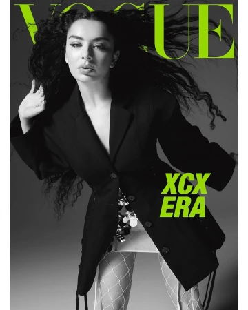 Charli XCX in black blazer and fishnet tights against grey background for magazine cover by Amy Troost