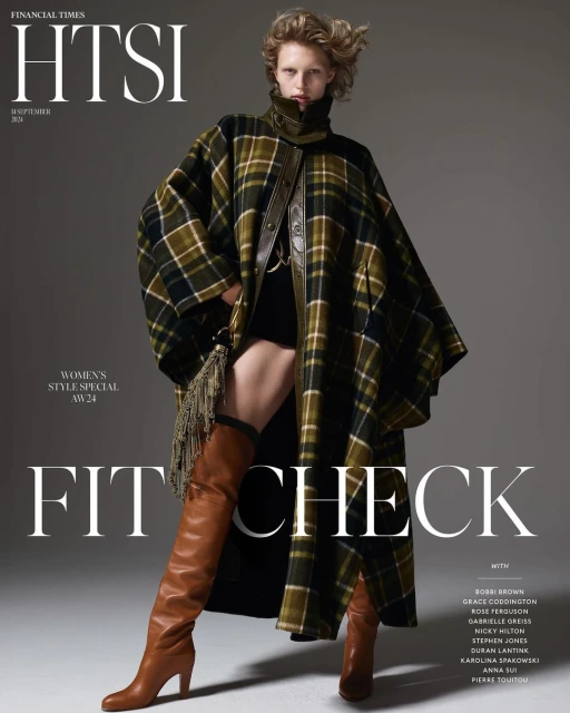 Fashion editorial featuring a woman in a plaid cape coat and thigh-high boots, Financial Times HTSI magazine cover, studio shot.
