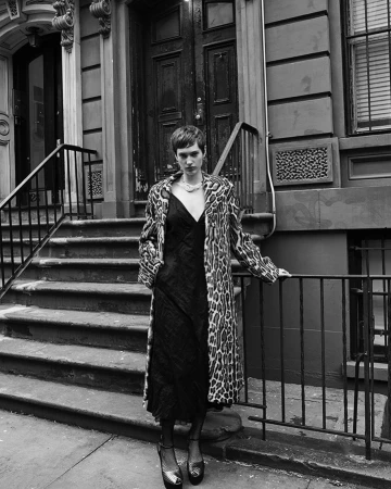 Model wearing a leopard print coat and dark slip dress standing on brownstone stoop by Amy Troost