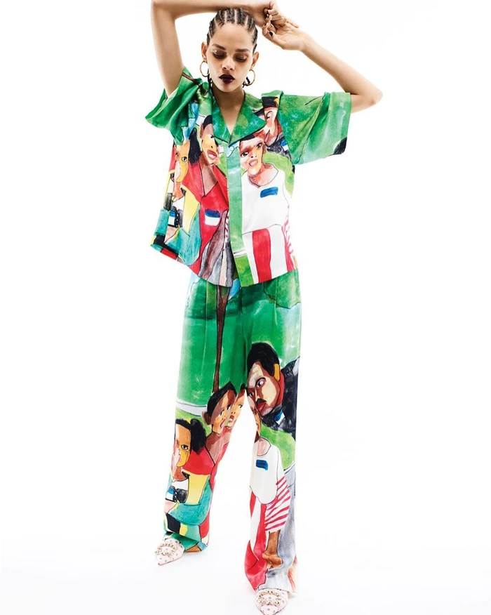 Model with braided hair in green printed short-sleeve shirt and matching trousers posing against a white background