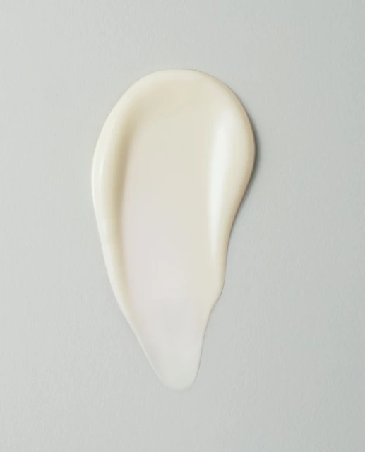 Close-up studio shot of white cream smear on a light gray backdrop, ideal for beauty or skincare product promotion.