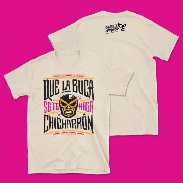 Two cream-colored t-shirts on a pink background. One shirt is facing forward, displaying a luchador mask and text, while the other is reversed.