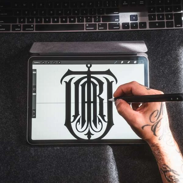 Artist working on a digital illustration with a tablet, stylus, and keyboard on a desk, showcasing digital art and creative tools.