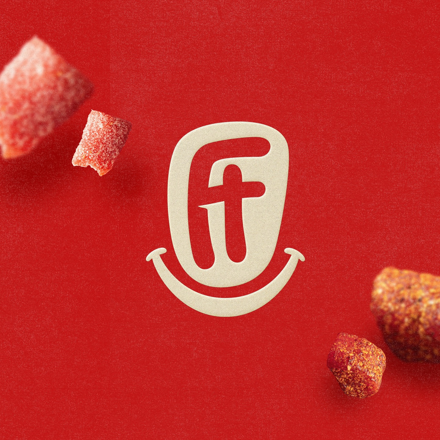 Close-up studio shot of the F&T logo on a red backdrop, with red candies adding visual interest, creating an appetizing and vibrant image.