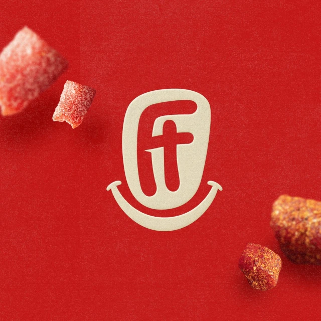 Close-up studio shot of the F&T logo on a red backdrop, with red candies adding visual interest, creating an appetizing and vibrant image.