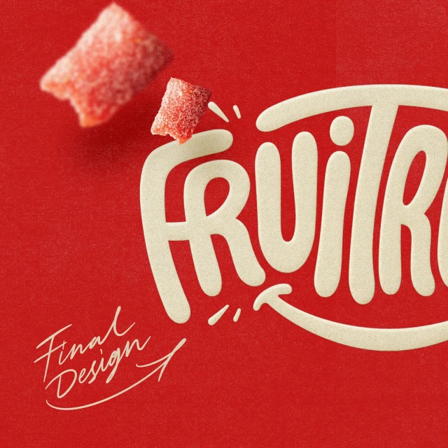 Close-up studio shot of two red, sugar-covered fruit candy pieces with the logo "FRUITR" against a textured red background.