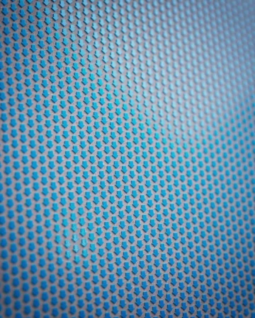 Close-up of a pattern featuring rows of downwards-pointing blue arrows on a gray background creating an abstract geometric texture.