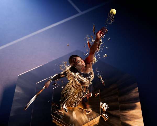Action shot of a woman in a gold dress hitting a tennis ball with a racket, captured against a backdrop of geometric shapes.