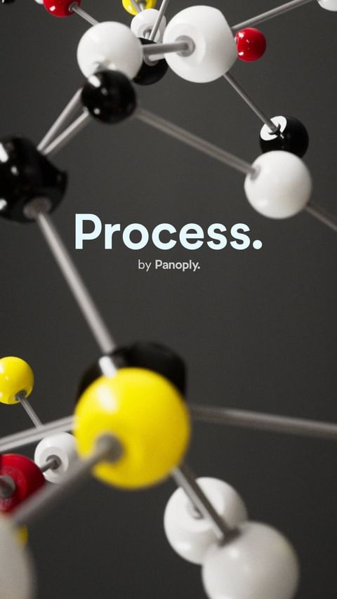 Abstract, shiny molecular structure with connected multi-colored spheres against a neutral grey background, highlighting the structure's design.