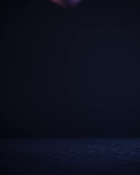 Dark, low-key image of a room with a blue-gray floor, shot in a photo studio. The background is a gradient of dark blue to black.