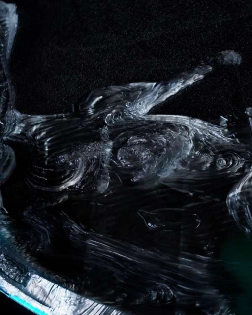 Abstract image features flowing, wave-like glass structures with dark background, creating an ethereal and dynamic visual effect.