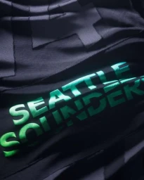 Close-up of black fabric with raised teal embroidery reading Seattle Sounders created by CGI artist Panoply