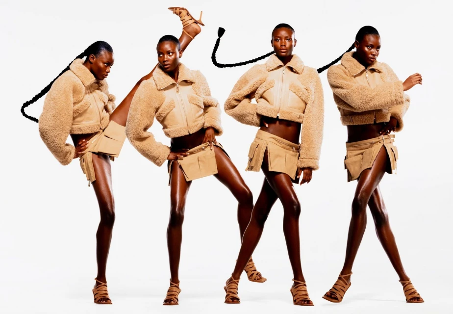 Fashion shot of a Black female model wearing a beige cropped shearling jacket and skirt, with multiple exposures against a white backdrop.