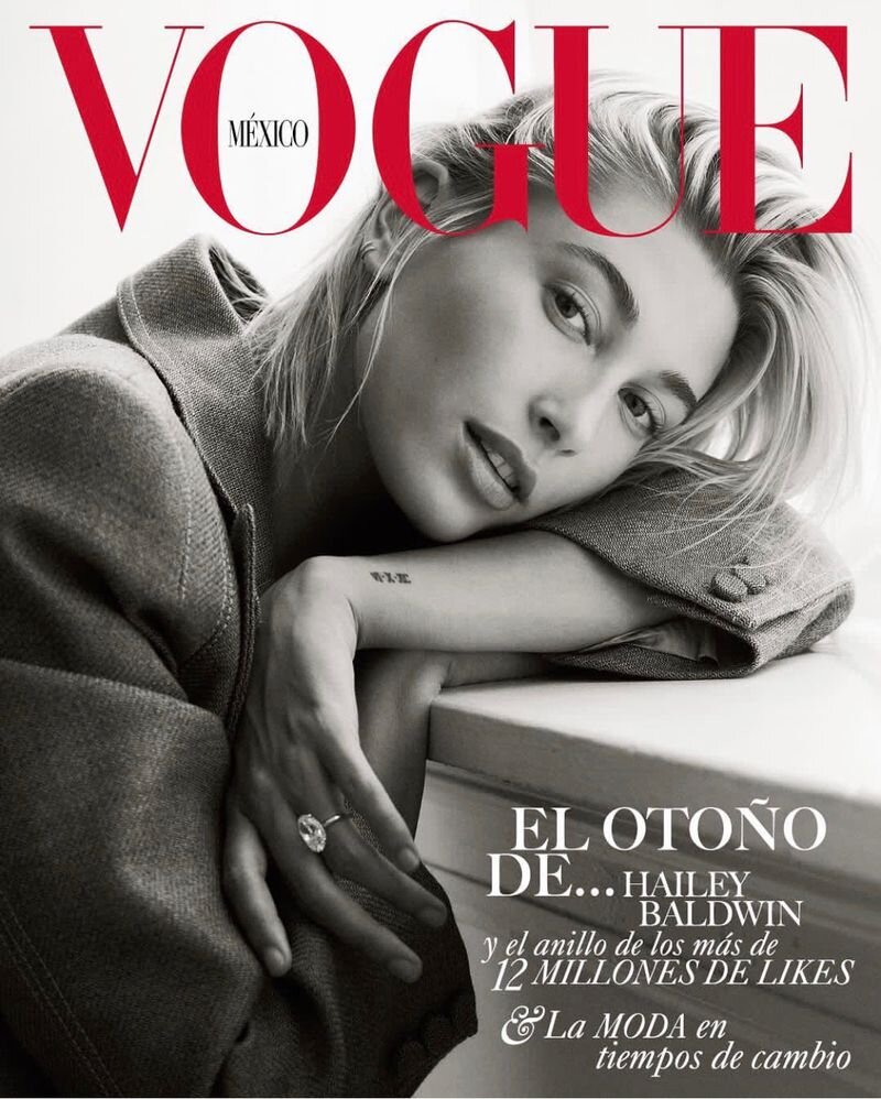 Vogue Mexico cover featuring Hailey Baldwin with a ring. Close-up shot in neutral tones and red typography, capturing a stylish editorial moment.