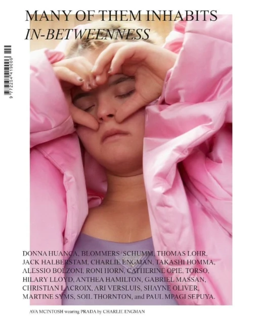 Magazine cover featuring a model in a pink puffer jacket making a heart shape with her hands over her closed eyes.