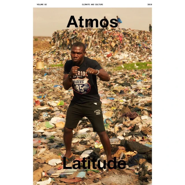Magazine cover featuring a Black man posing as a boxer in front of a trash pile, wearing a black t-shirt and shorts.