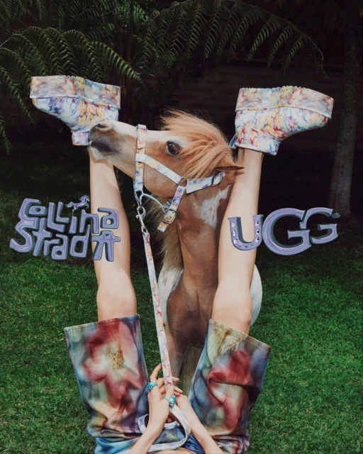 Eye-level fashion shot showcasing a small horse head juxtaposed with a person's legs in patterned boots and pants against a green background.