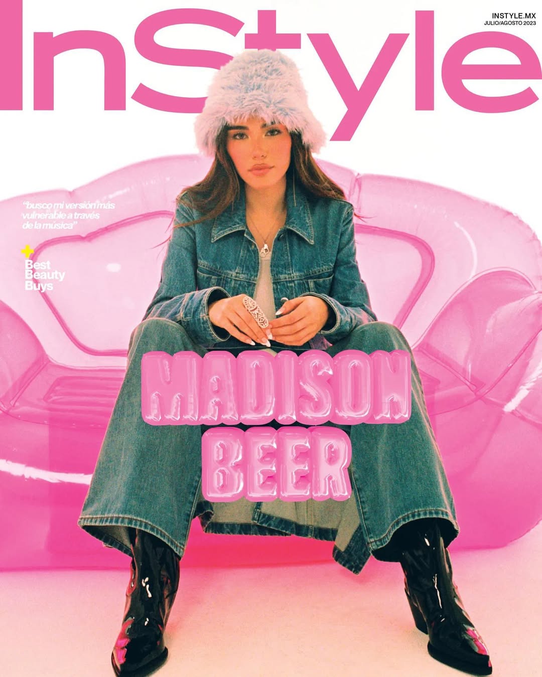Magazine cover featuring Madison Beer seated in a pink inflatable chair, wearing a denim jacket, jeans, black patent boots, and a furry hat.
