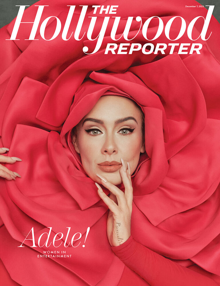 Adele poses on The Hollywood Reporter cover. Dressed in a large red rose-like garment, she rests a manicured hand near her face.