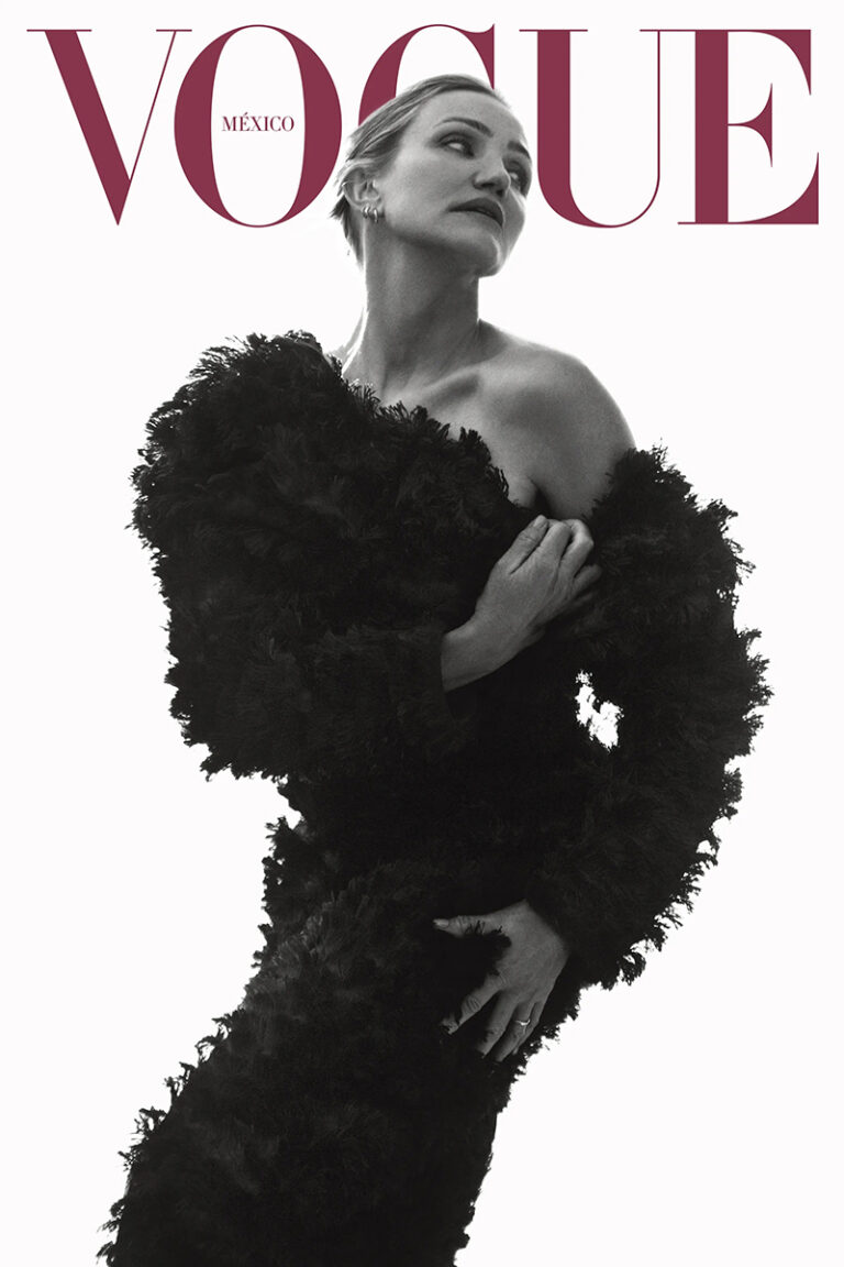 Black and white portrait of a woman wearing a textured black off-the-shoulder dress against a bright white background.