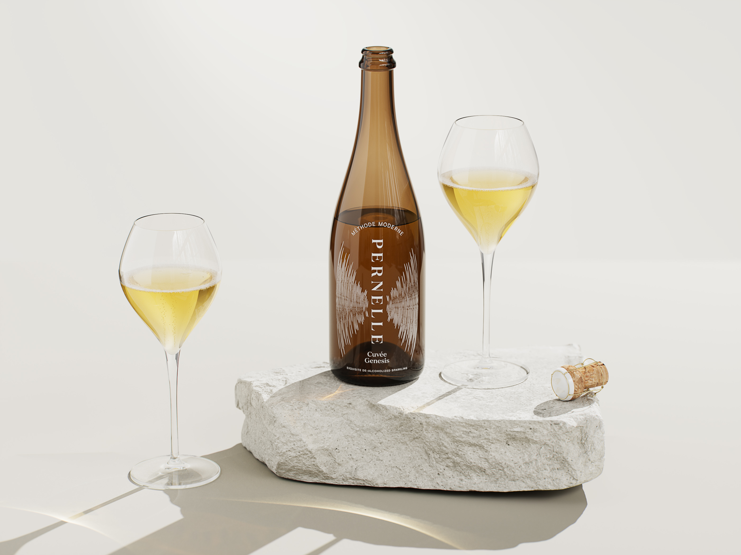 Still life shot of an amber bottle of sparkling wine with two wine glasses, a stone block, and a wine cork on an off-white background.