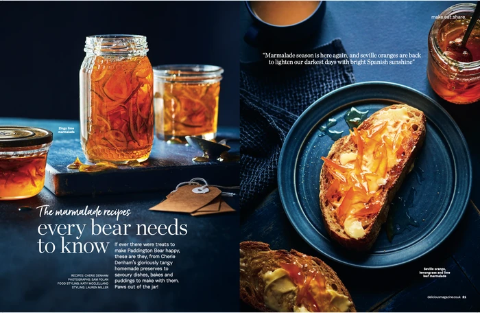 Glass jars of golden orange marmalade alongside a slice of buttered toast on a blue plate styled in Sydney