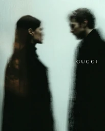 Two figures facing each other behind a textured glass pane with Gucci text visible in the center