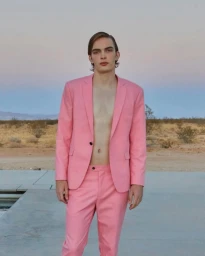 A young male model with styled hair wearing a pink suit without a shirt outdoors in Los Angeles.