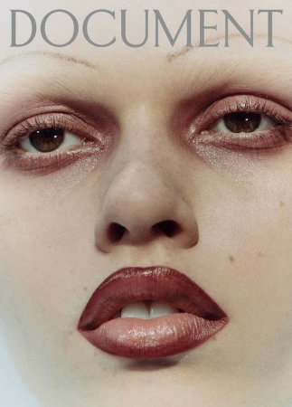 Close-up portrait of a woman's face with makeup, featuring glossy red lips and brown eyes, against a light background with the text 'DOCUMENT' above.