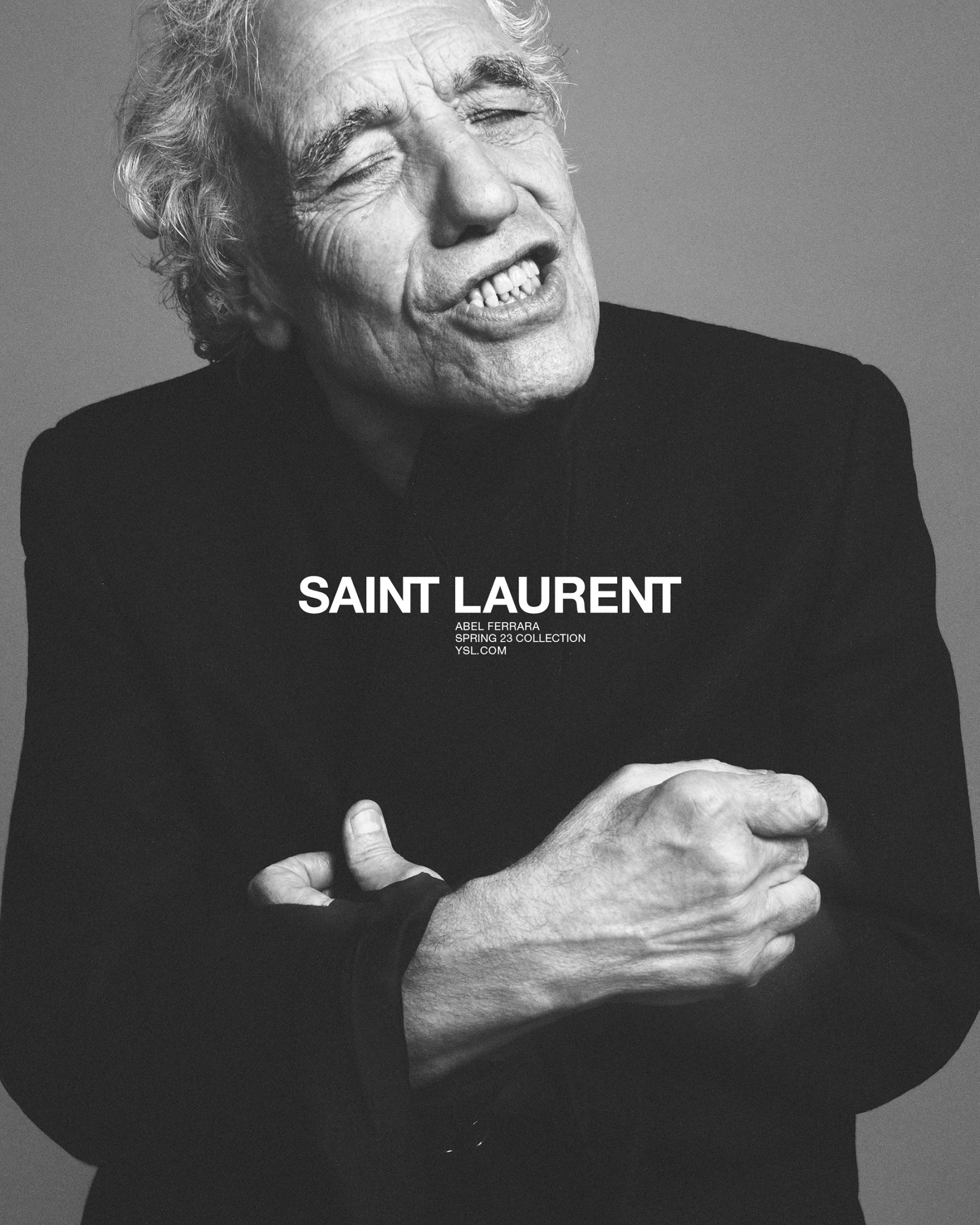 Black-and-white portrait of an elderly man in a suit, Adel Ferrara, for Saint Laurent, with focus on face and brand text overlay.