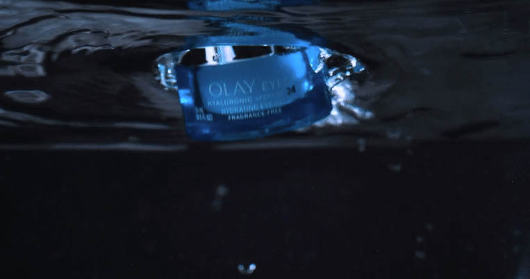 Eye cream jar under water. Blue jar of Olay Eyes 24 hydrating eye cream surrounded by water.