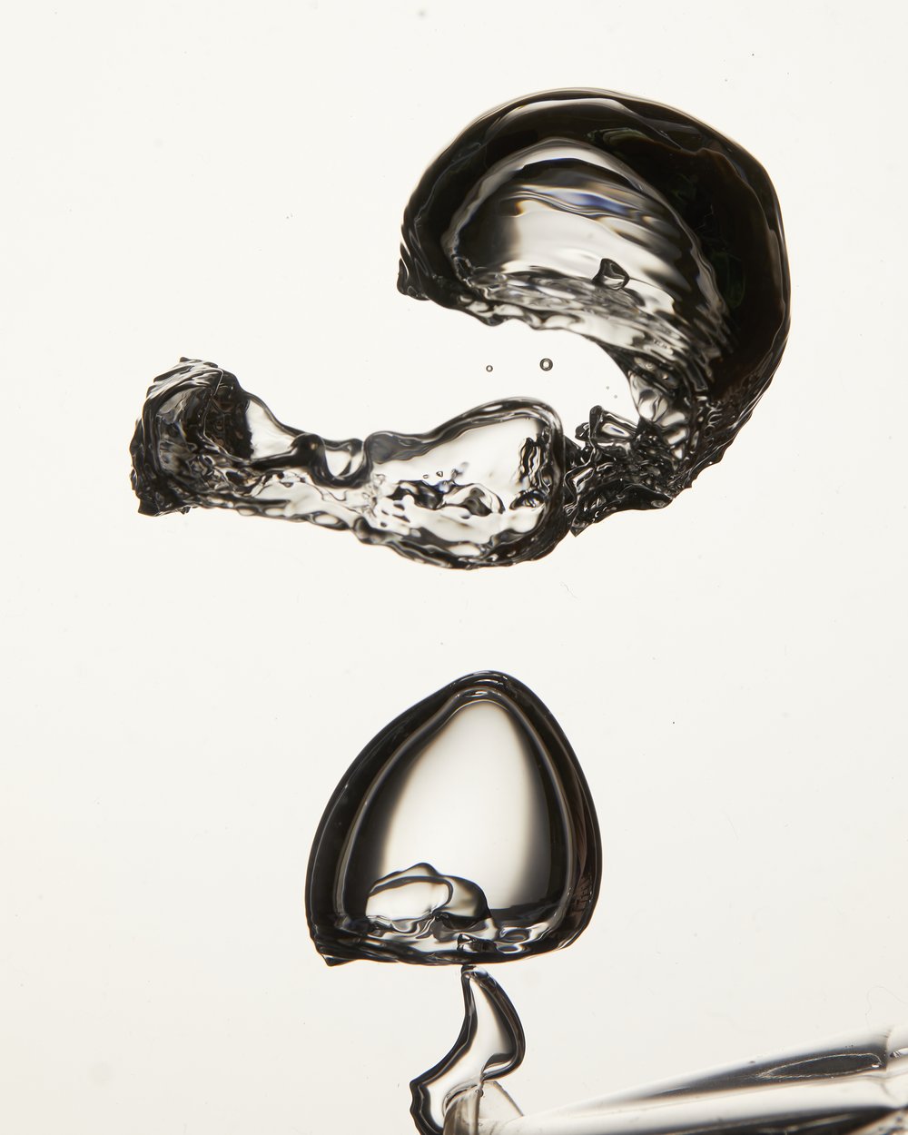 Macro photograph of two transparent water bubbles, one with a unique shape and the other more rounded, against a clean white backdrop.