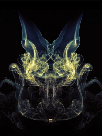 Abstract symmetrical smoke pattern against a black background, featuring delicate wisps of yellow, blue, and white smoke creating a ghostly figure.