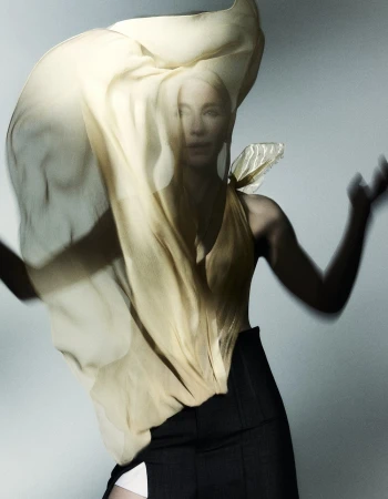 Woman in motion with flowing yellow fabric. Beauty shot in studio with movement, fashion, and a modern, ethereal feel and creative lighting.