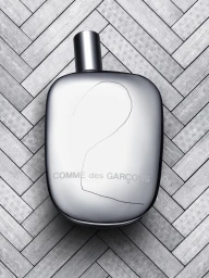 Silver metallic perfume bottle with handwritten number two on parquet tile background