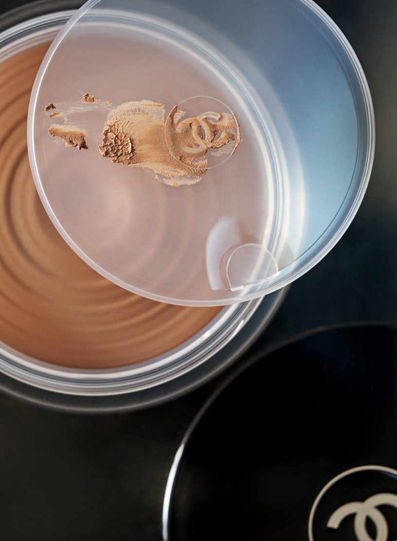 Close-up of bronze Chanel bronzer powder, highlighting the texture, shimmer, and iconic logo, showcasing luxury beauty and makeup artistry.