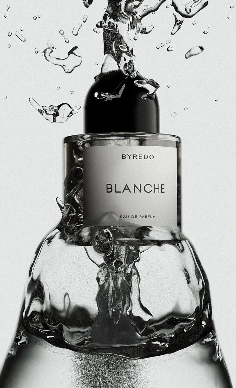 Byredo Blanche perfume bottle close-up surrounded by splashing water against a clean, bright backdrop in a beauty advertisement.
