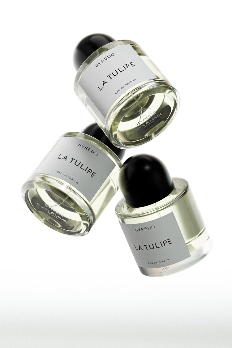 Three Byredo La Tulipe perfume bottles are stacked on a white background, showcasing the minimalist design and clear liquid inside.