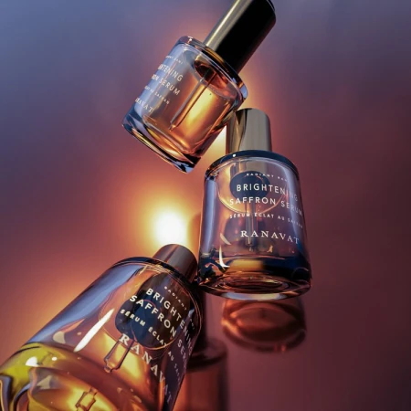 Three bottles of Ranavat Brightening Saffron Serum, arranged in a visually striking composition, showcase elegance and skincare.