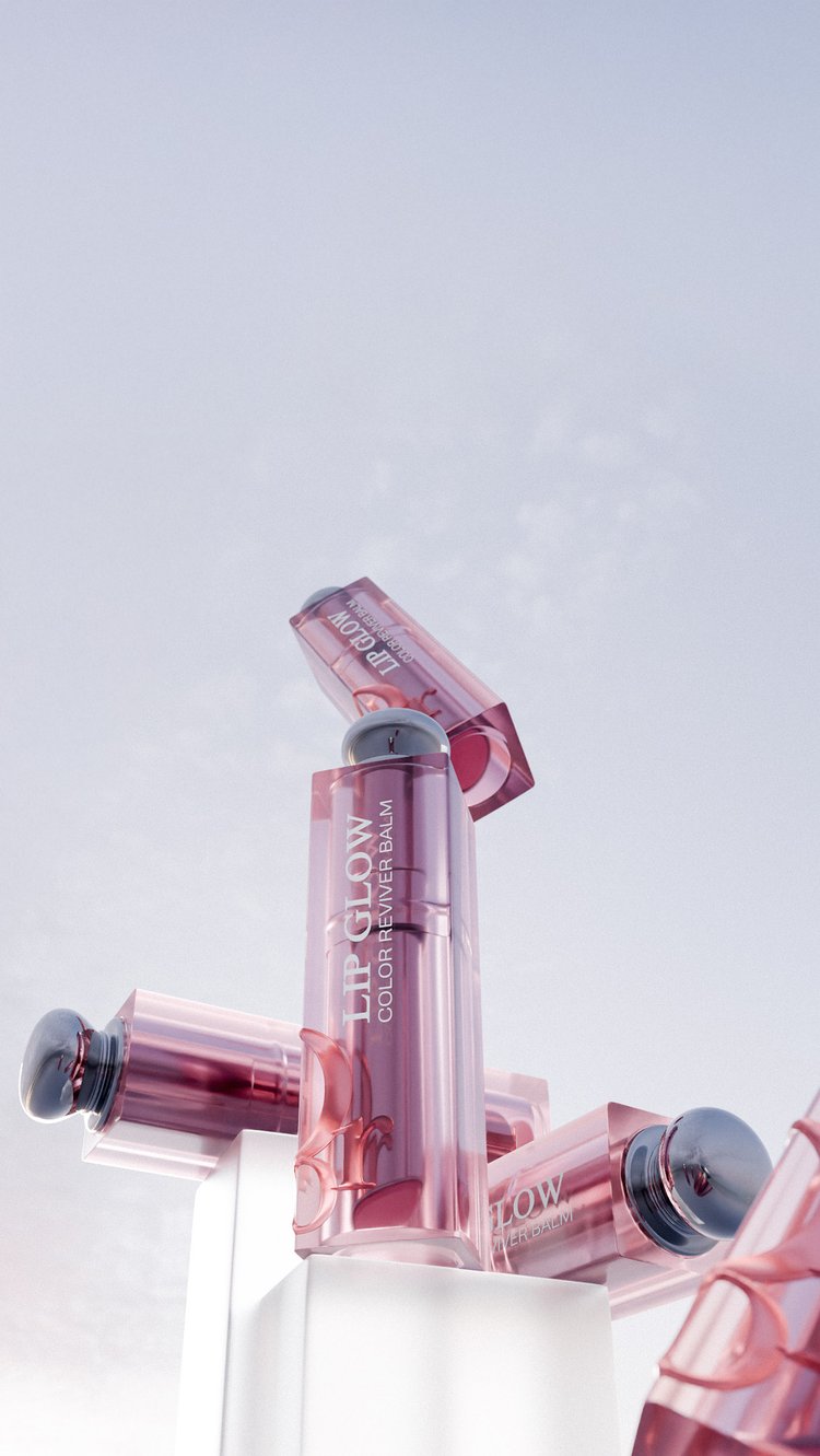 Lip Glow Color Reviver Balm displayed on a white podium in a product shot featuring pink and transparent packaging.