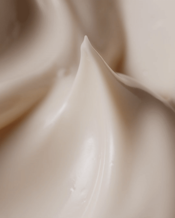 Close-up of beige cream, showcasing its smooth, glossy texture and swirls. Perfect for beauty, skincare, and cosmetic concepts.