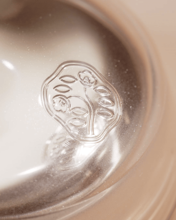 Close-up shot of an antique silver bowl with an embossed floral design, showcasing its intricate details and metallic luster.