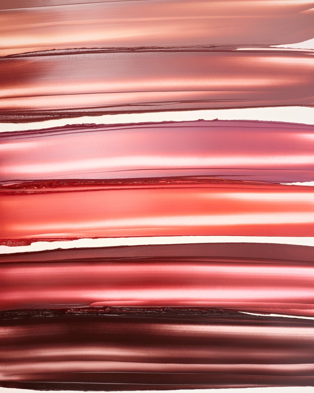 Close-up of smeared lipstick samples in various shades of red, pink, and nude. Cosmetic swatches for beauty and makeup concepts.