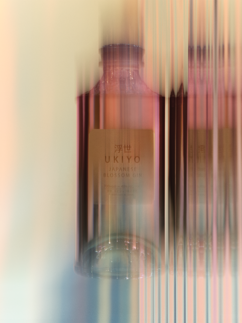 Two bottles of Ukiyo Japanese Blossom Gin with peach and brown coloring, soft focus, and vertical motion blur.