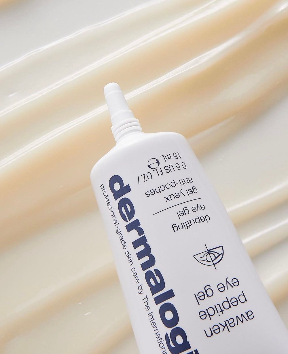 White tube of Dermalogica Awaken Peptide Eye Gel against soft beige background with textured gel product streaks.
