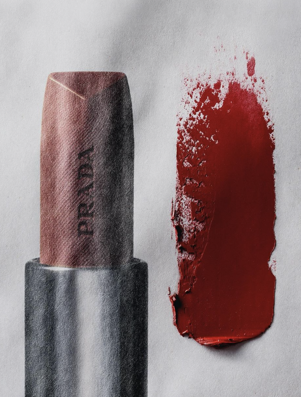 Still life shot of Prada lipstick, with a smear of lipstick on a white background, product shot for beauty and makeup concept.