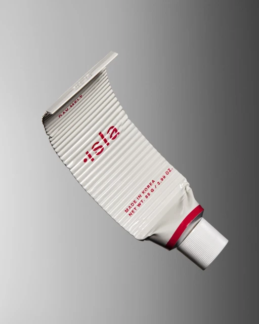 White tube of isla brand cream against a graduated gray background, displaying product packaging and brand logo with clean product photography.
