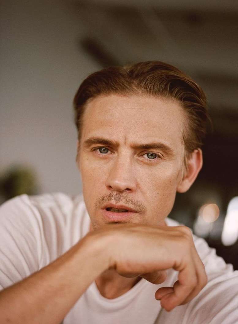 Close-up portrait of a man in a white t-shirt resting his chin on his hand by photographer Ryan Brabazon